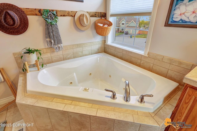 full bathroom featuring a tub with jets and vanity