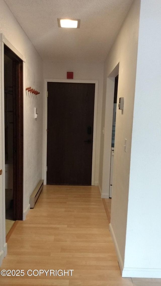 400 W 76th Ave # 204, Anchorage, AK 99518 - hall with a baseboard radiator, light wood-style floors, and baseboards