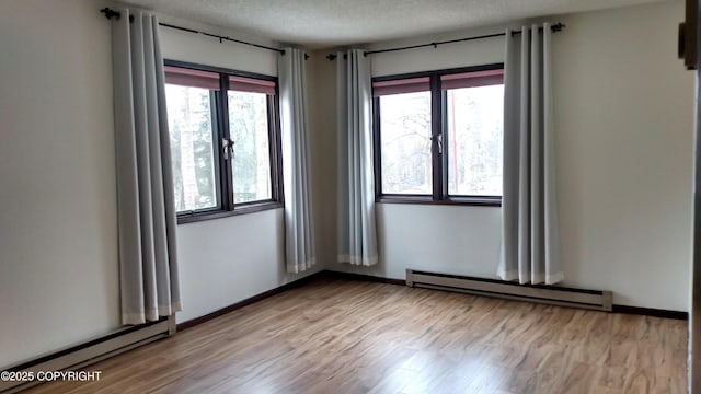 400 W 76th Ave # 204, Anchorage, AK 99518 - spare room featuring baseboard heating, light wood-style floors, a textured ceiling, and baseboards