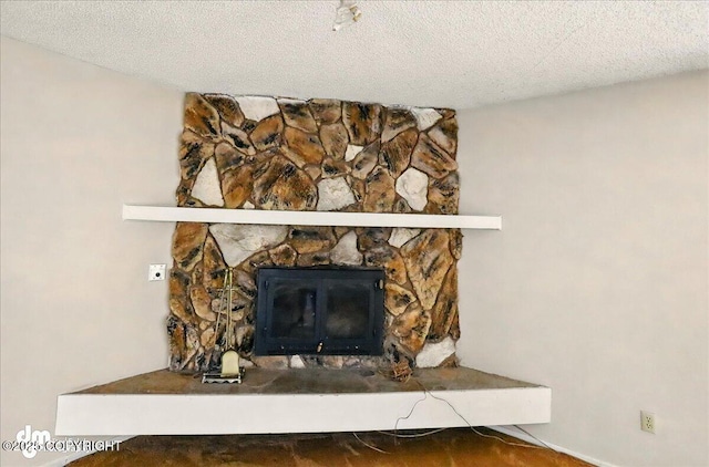 detailed view of a fireplace and a textured ceiling