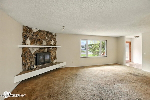 unfurnished living room featuring a fireplace, a textured ceiling, and carpet flooring