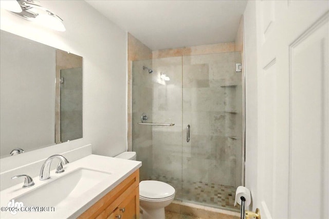 bathroom featuring a stall shower, toilet, and vanity