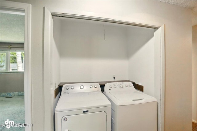 clothes washing area featuring washer and dryer, carpet, and a textured ceiling
