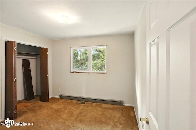 unfurnished bedroom with carpet, a baseboard radiator, and baseboards
