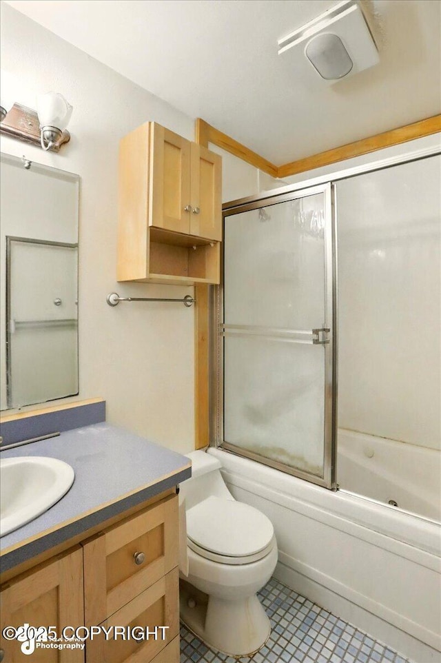 bathroom with vanity, enclosed tub / shower combo, toilet, and tile patterned flooring
