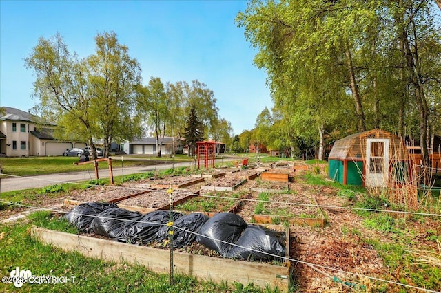 view of yard featuring a garden, an outbuilding, and a greenhouse