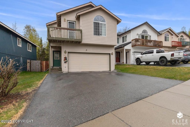 view of front of property featuring a balcony, an attached garage, and driveway