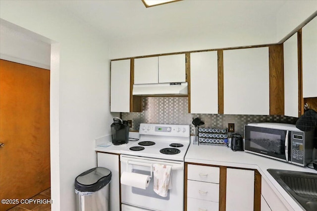 kitchen with white electric range, under cabinet range hood, light countertops, a sink, and tasteful backsplash