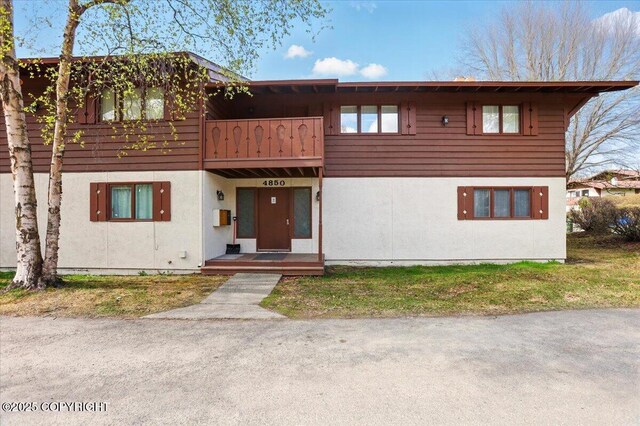 townhome / multi-family property featuring a balcony and stucco siding
