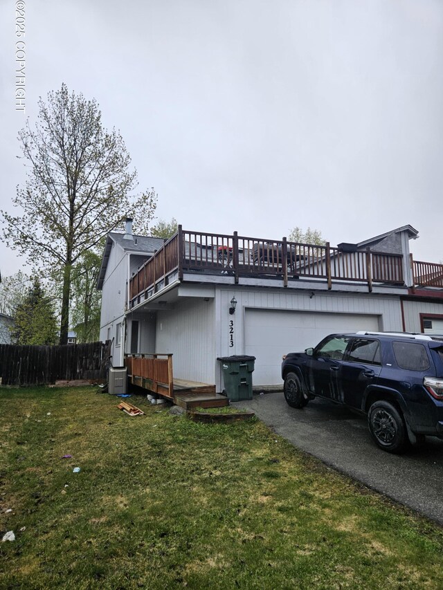 view of property exterior with an attached garage, asphalt driveway, and central AC