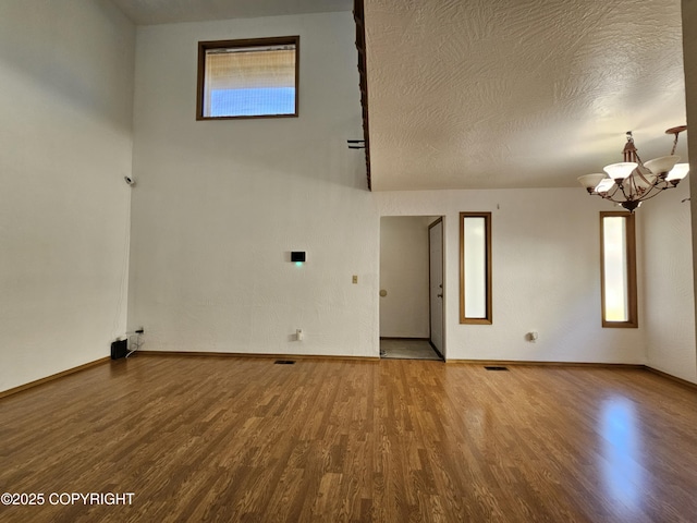 3213 Tayshee Cir, Anchorage, AK 99504 - spare room with a chandelier, wood finished floors, baseboards, and a textured ceiling
