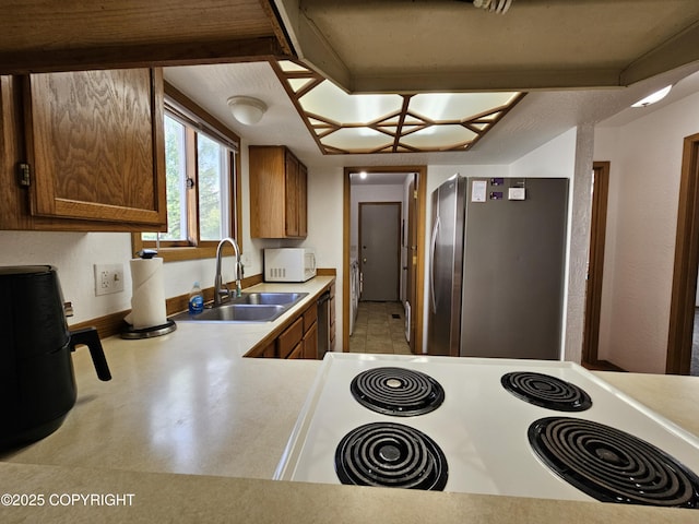 3213 Tayshee Cir, Anchorage, AK 99504 - kitchen featuring a sink, electric stove, freestanding refrigerator, white microwave, and light countertops