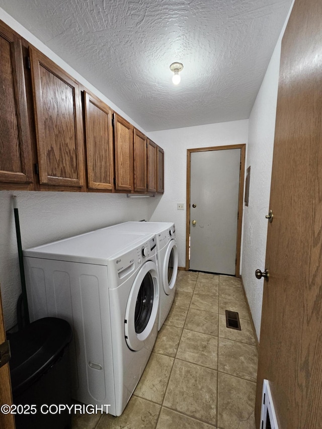 3213 Tayshee Cir, Anchorage, AK 99504 - laundry room with washing machine and dryer, cabinet space, a textured ceiling, and light tile patterned flooring