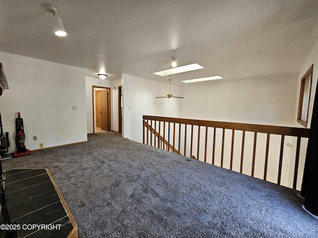 3213 Tayshee Cir, Anchorage, AK 99504 - empty room with carpet floors, a skylight, a ceiling fan, and a textured ceiling