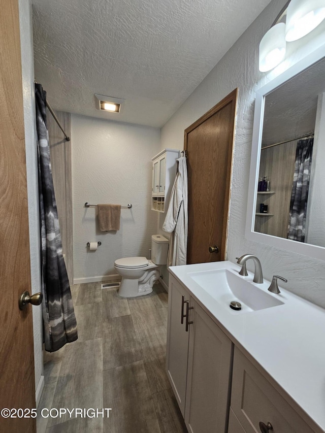 3213 Tayshee Cir, Anchorage, AK 99504 - full bath with toilet, wood finished floors, vanity, a textured ceiling, and a shower with shower curtain