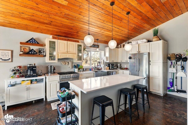 kitchen with high end appliances, wooden ceiling, a breakfast bar area, light countertops, and vaulted ceiling