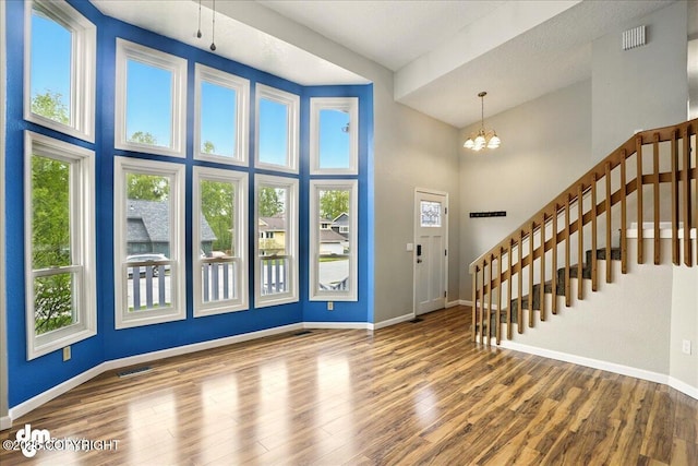 9033 W Parkview Terrace Loop, Eagle River, AK 99577 - foyer entrance featuring baseboards, wood finished floors, a chandelier, a high ceiling, and stairway