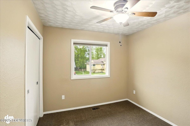 9033 W Parkview Terrace Loop, Eagle River, AK 99577 - unfurnished bedroom with dark colored carpet, a closet, baseboards, and a ceiling fan