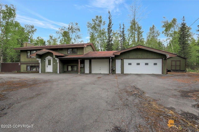view of front of property with a garage and asphalt driveway