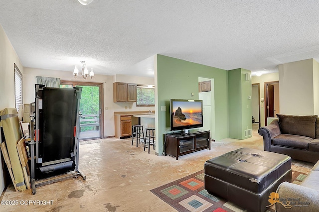 living area featuring a textured ceiling and a chandelier