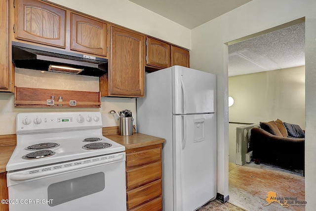 kitchen with white appliances, under cabinet range hood, light countertops, brown cabinets, and a textured ceiling