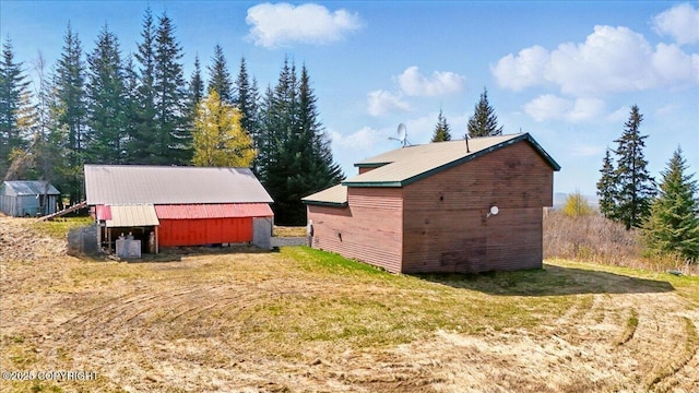 34540 Alamar, Anchor Point, AK 99556 - view of side of home featuring an outbuilding, a lawn, and metal roof