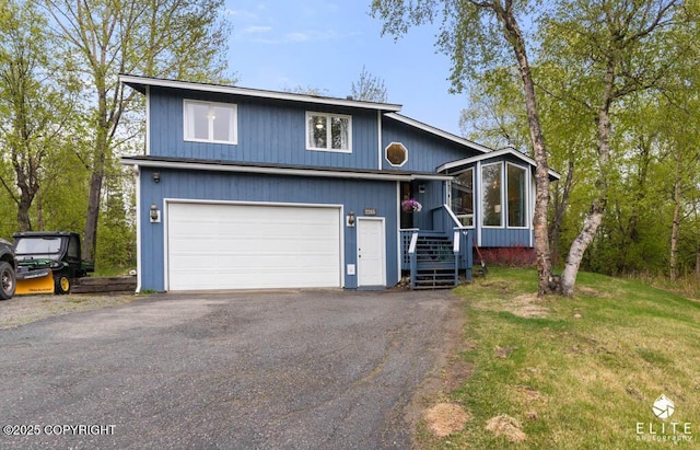 view of front of home featuring driveway, a sunroom, and a front lawn