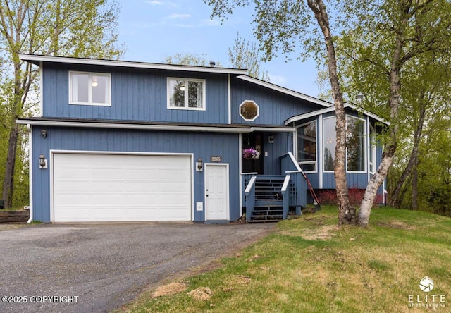view of front of house with asphalt driveway, a garage, and a front lawn