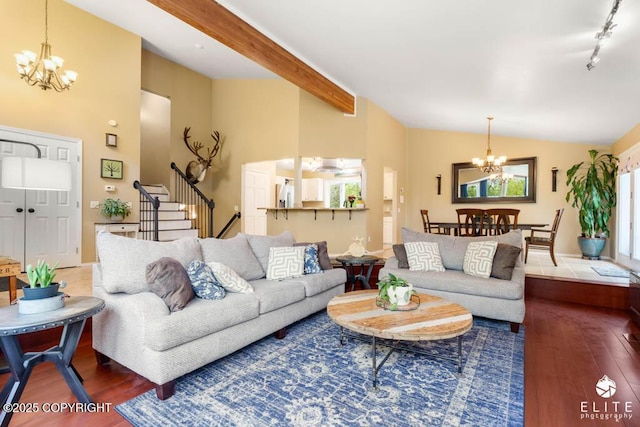 living area with a chandelier, wood finished floors, and stairs