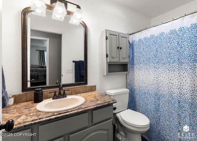 full bathroom with vanity, toilet, and curtained shower