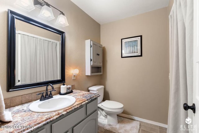 full bath featuring toilet, vanity, and baseboards
