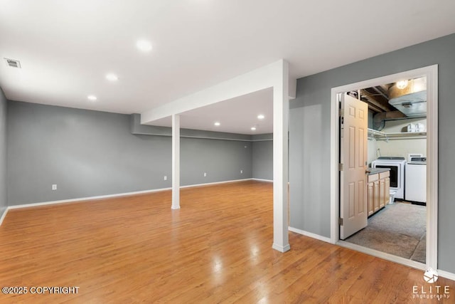 finished below grade area with baseboards, independent washer and dryer, light wood-type flooring, and recessed lighting