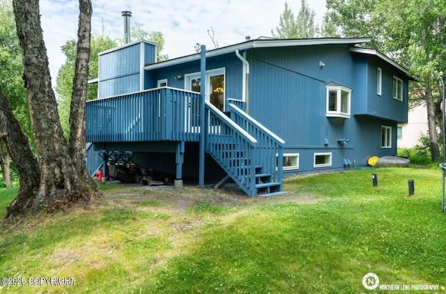 rear view of property featuring a yard, a wooden deck, and stairs