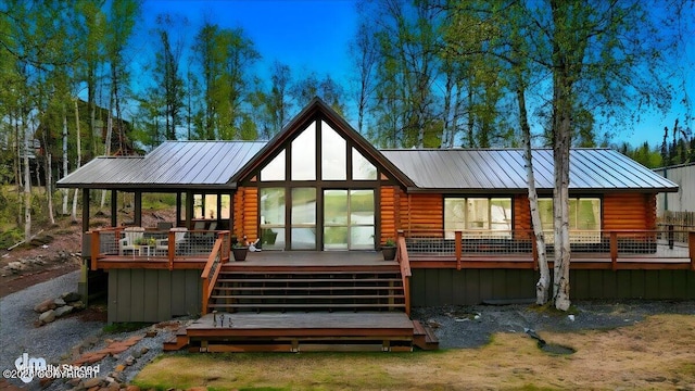 back of house with metal roof, a deck, log siding, and stairs