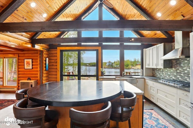 dining area with wood ceiling, a water view, rustic walls, baseboard heating, and recessed lighting