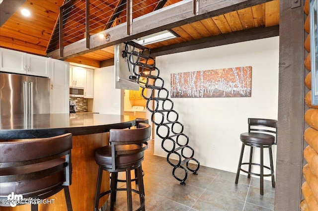 bar area featuring stainless steel appliances, wooden ceiling, and decorative backsplash
