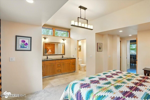 bedroom with a sink, ensuite bath, light tile patterned flooring, and recessed lighting