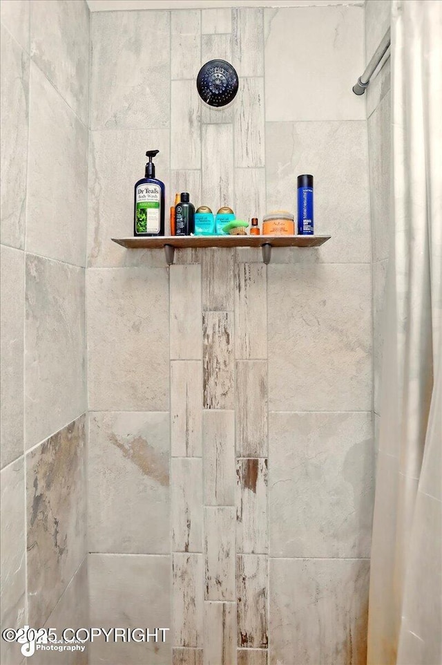 bathroom view of a tile shower and a dry bar