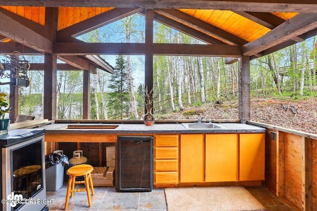 sunroom with beverage cooler, healthy amount of natural light, and a sink