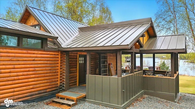 back of property with a standing seam roof, metal roof, and log exterior