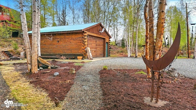 view of outdoor structure featuring a garage, an outbuilding, and driveway