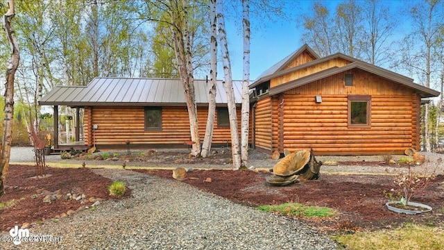 view of side of home featuring log exterior and metal roof