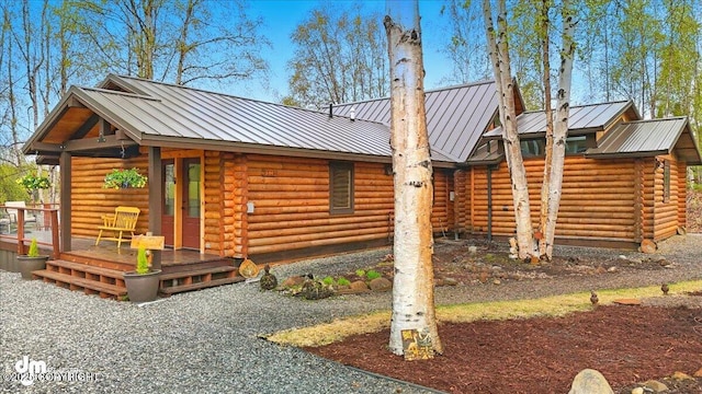 view of front facade featuring log exterior, metal roof, and a standing seam roof