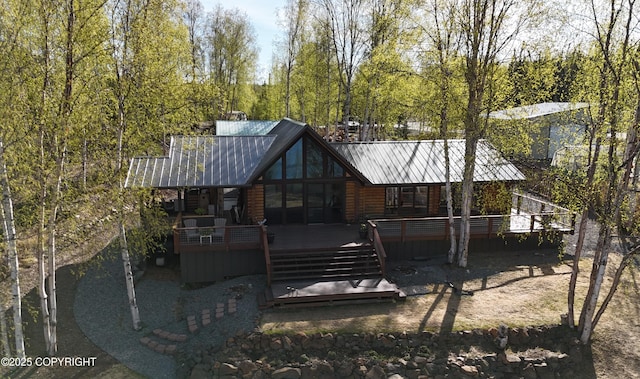 back of house with a wooden deck and metal roof