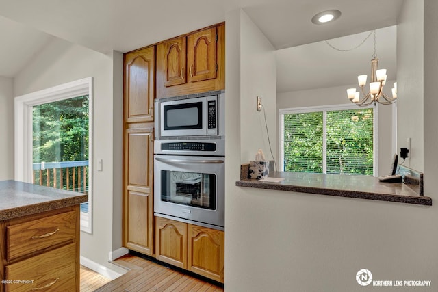 19426 Pribilof Loop, Eagle River, AK 99577 - kitchen with appliances with stainless steel finishes, light wood-style floors, plenty of natural light, and brown cabinetry