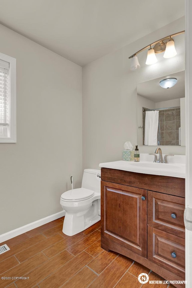19426 Pribilof Loop, Eagle River, AK 99577 - full bathroom featuring vanity, toilet, wood finished floors, baseboards, and a shower with curtain