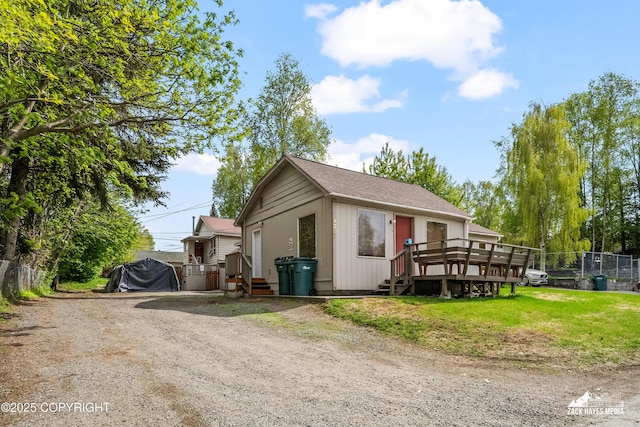 4207 Cope St, Anchorage, AK 99503 - view of front of house featuring dirt driveway, a wooden deck, and roof with shingles