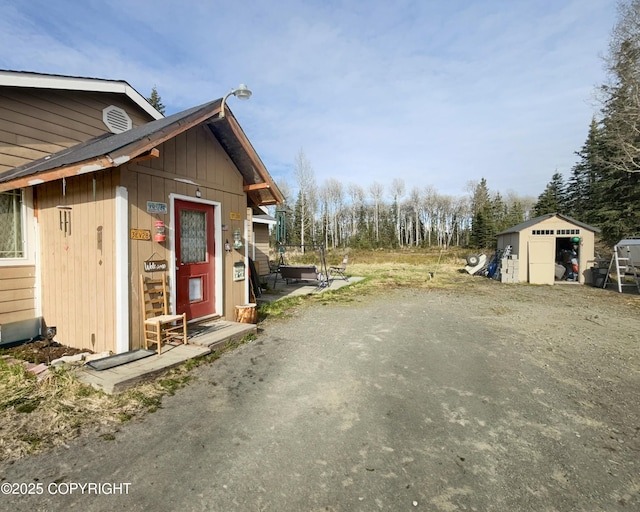view of property exterior with an outdoor structure and a storage shed