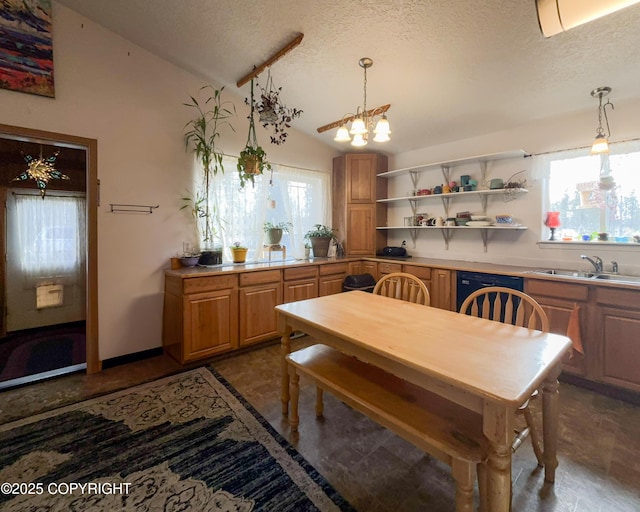 kitchen featuring a sink, a textured ceiling, lofted ceiling, dishwasher, and plenty of natural light
