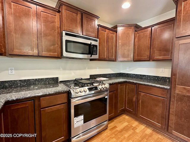 5612 Grand Teton Loop, Anchorage, AK 99502 - kitchen with appliances with stainless steel finishes, light wood-style flooring, dark stone counters, and recessed lighting